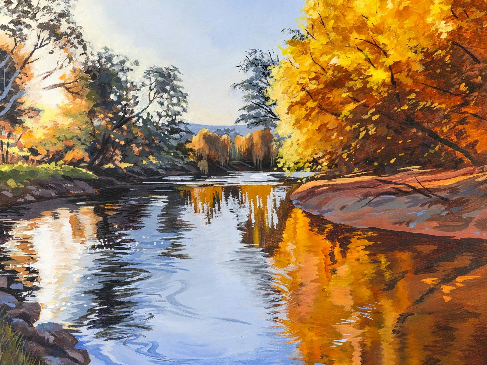 Image of golden trees on the side of a river.